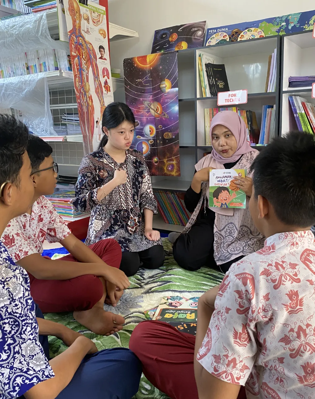 Guru membacakan buku di perpustakaan